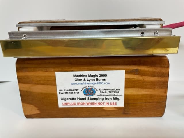 A Machine Magic 2000 stamping iron resting on its wooden stand