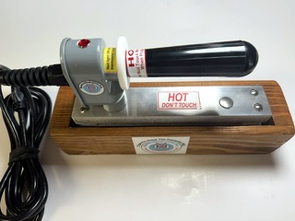 MM 10BK standard 2x5 ten stamp iron with black handle resting in its wooden stand