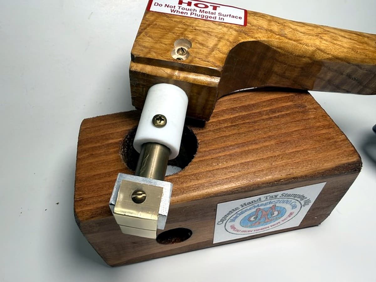MM 4TS two stamp iron with wood handle beside its wooden stand