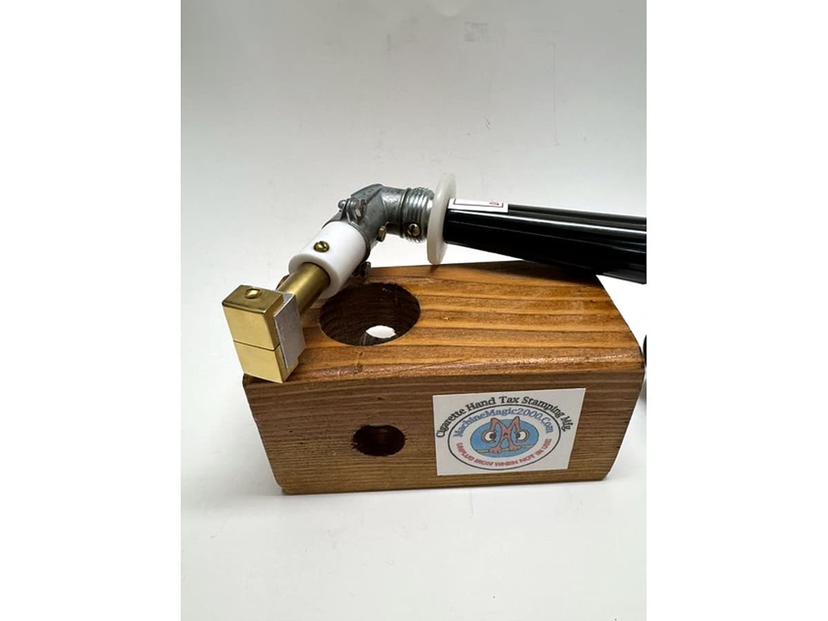 MM 8TS two stamp iron with black handle beside its wooden stand